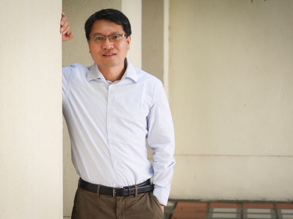 Dr. Rui Chen standing in front of a building