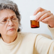 Elderly woman holding a pill bottle
